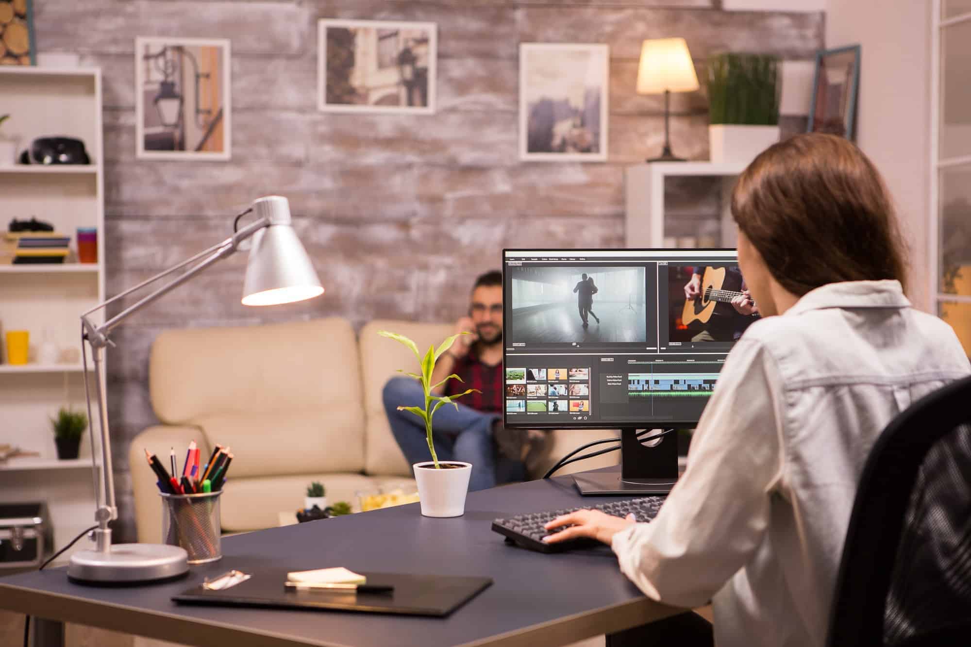 Creative female videographer working on a movie using her home computer
