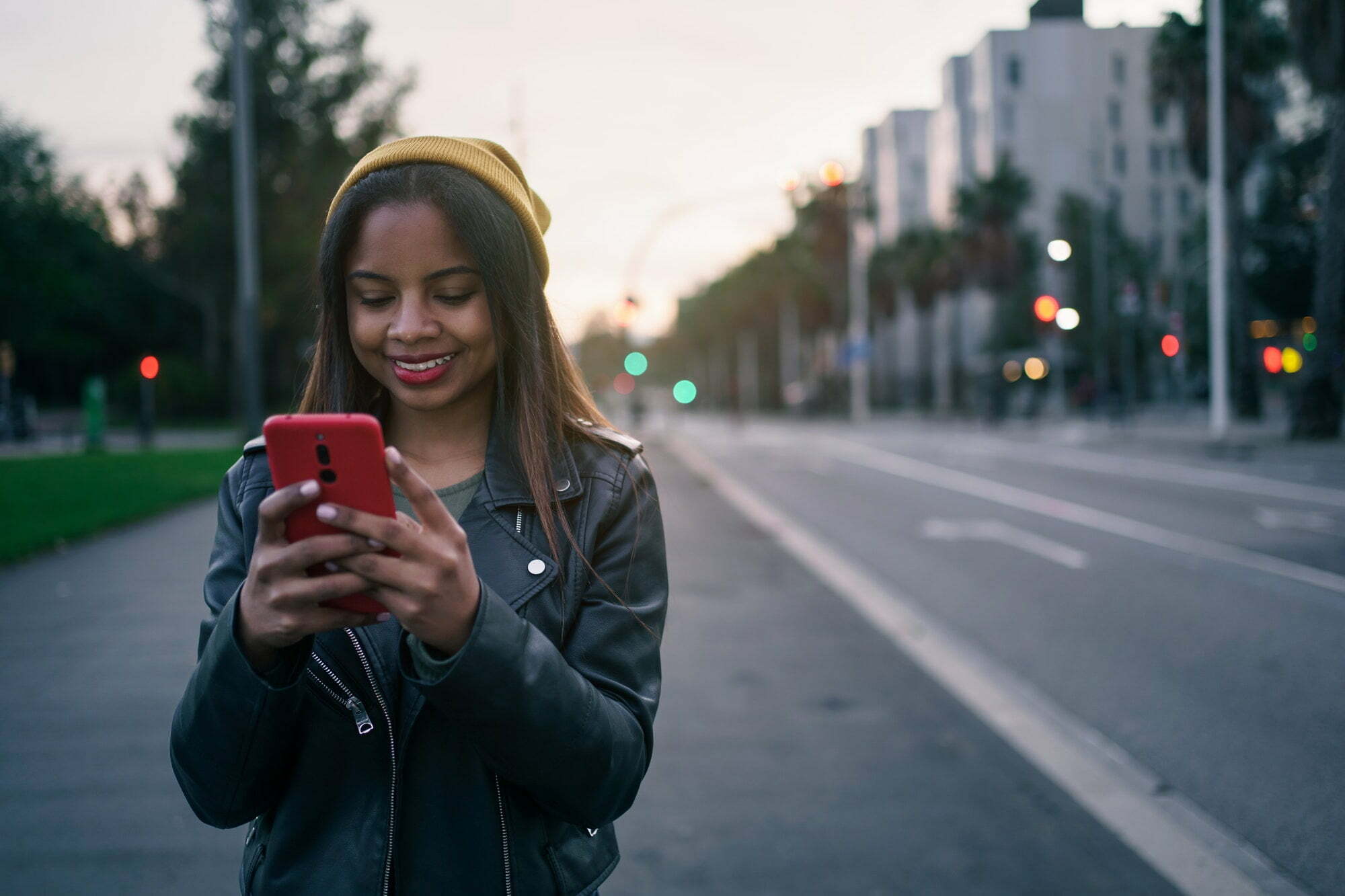 Fashion young African American Woman in stylish leather jacket sharing pics on social media