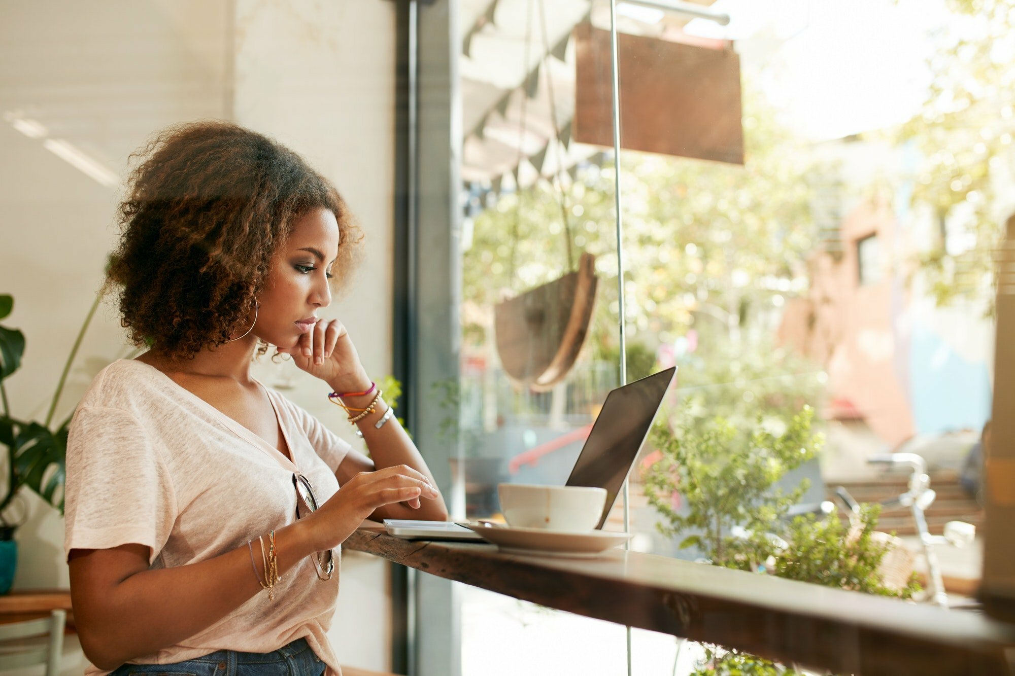 Young black woman at cafe using laptop